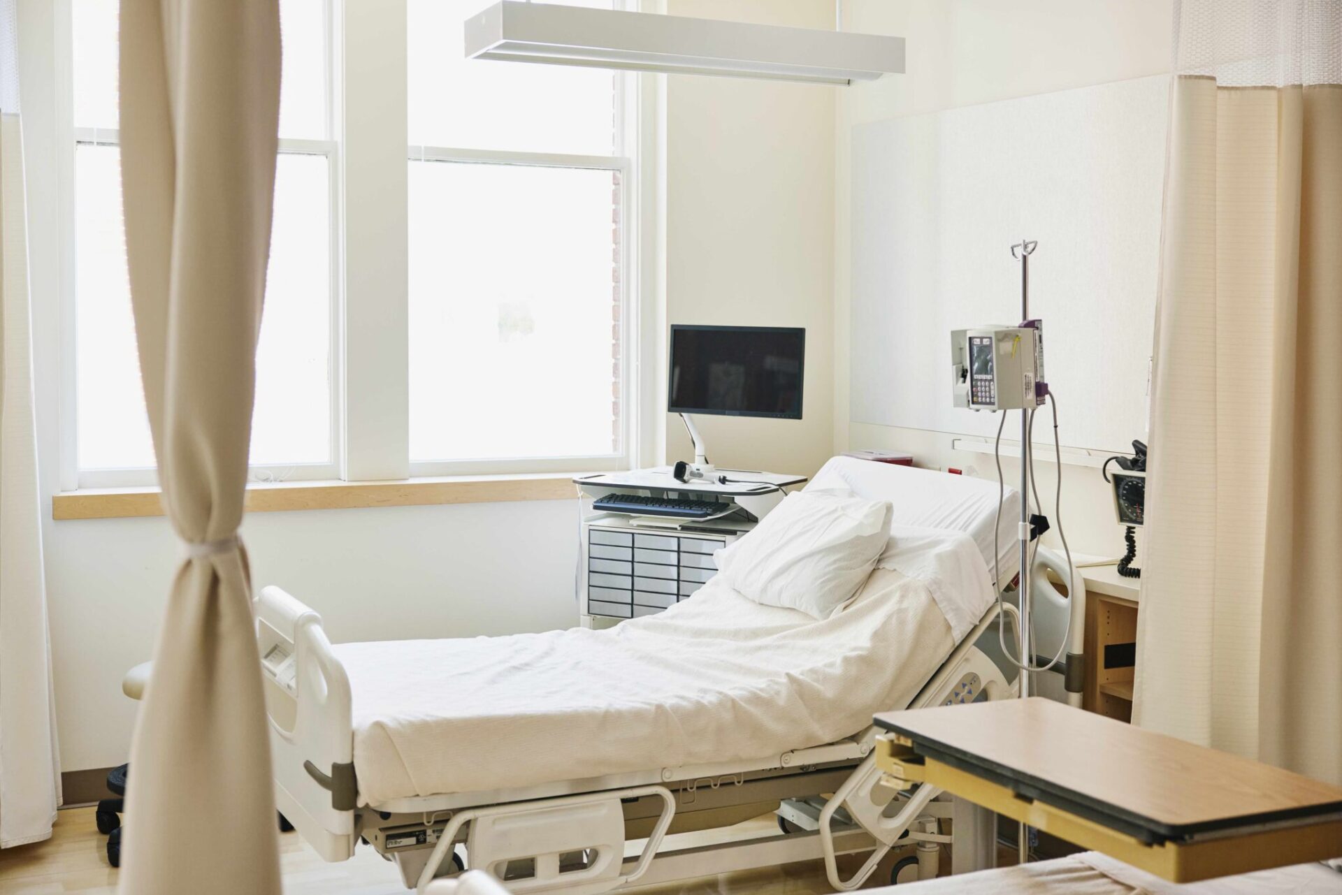 Wide shot of empty hospital bed in emergency room