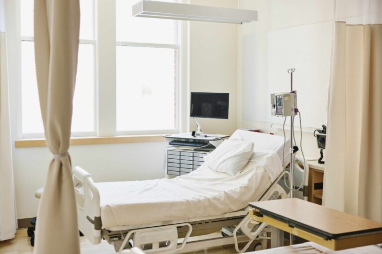 Wide shot of empty hospital bed in emergency room