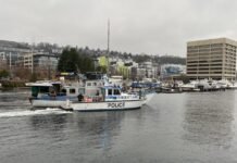 The Seattle Police Department’s Harbor Patrol Unit tows away a derelict vessel leaking fuel in Lake Union.