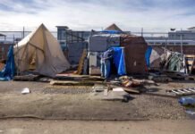 State bill would prohibit local bans on encampments in Washington An outreach worker visits an encampment in Seattle in 2022