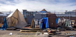 An outreach worker visits an encampment in Seattle in 2022