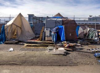 An outreach worker visits an encampment in Seattle in 2022