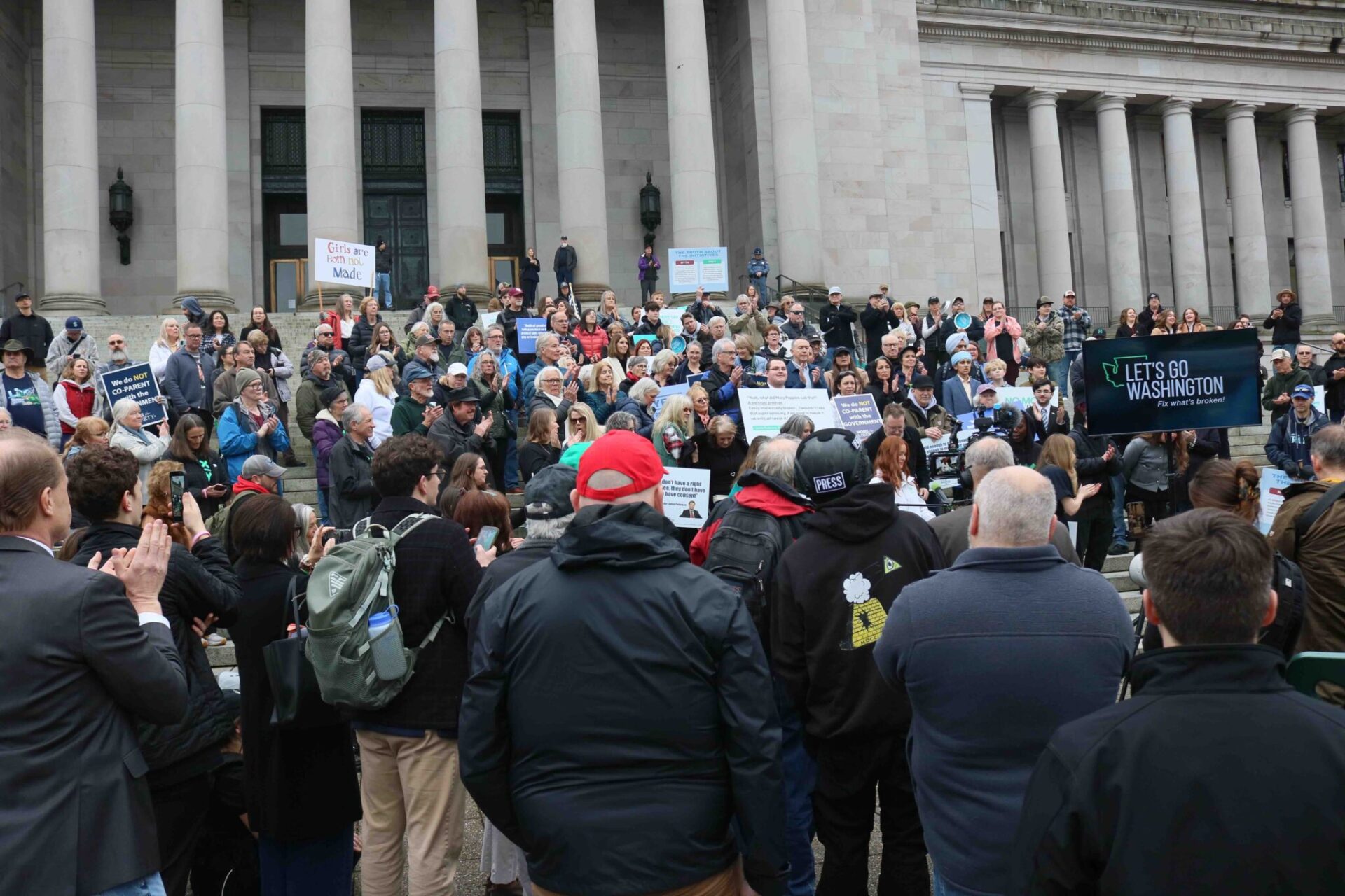 Supporters of Let’s Go Washington initiatives intended to bolster parental rights and block transgender athletes from girls’ sports, gather on the north steps of the Washington state Capitol on Tuesday, Feb. 3, 2026