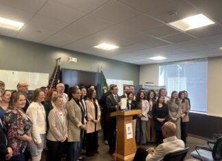 Washington Gov. Bob Ferguson stands alongside lawmakers and housing advocates after signing House Bill 2266 into law on Friday, March 27, 2026, in Everett.