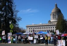Third round of ‘No Kings’ protest draws thousands to Washington’s state capitol Protesters lined the street near the Washington state capitol campus waving political signs on March 28, 2026.