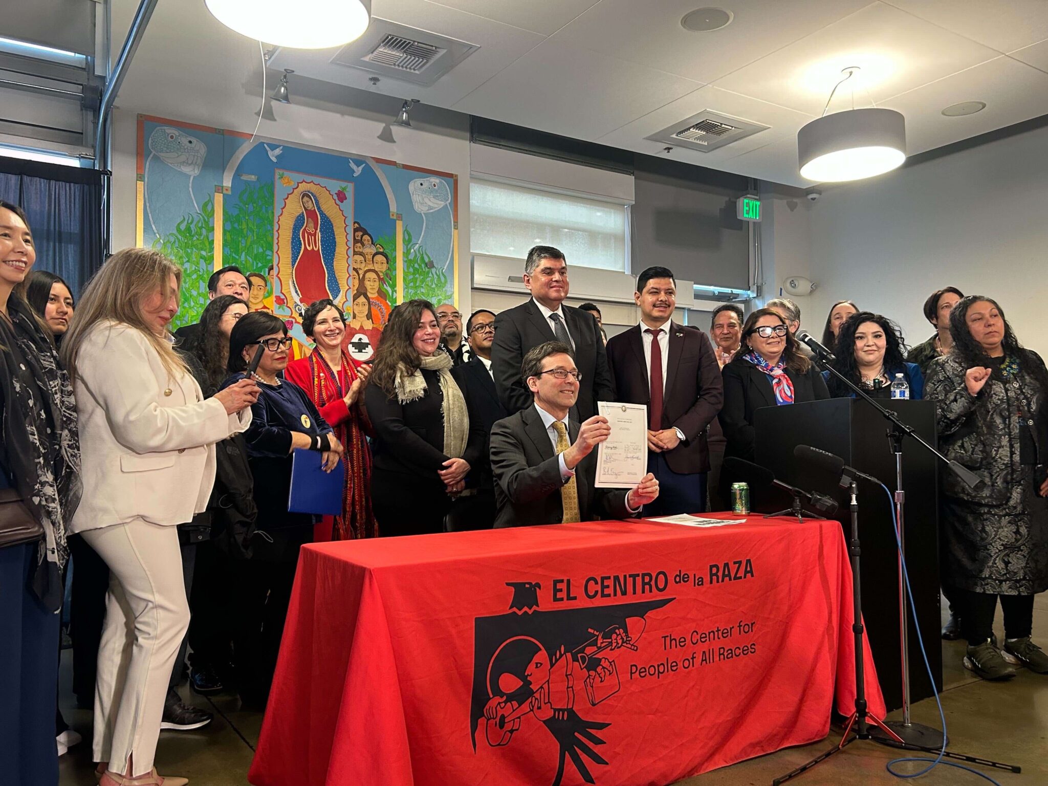 Gov. Bob Ferguson holds up a newly signed law banning law enforcement officers from wearing face coverings, on March 19, 2026 in Seattle. (Photo by Jake Goldstein-Street/Washington State Standard)