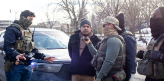 ICE agents allow a driver to talk to his wife as they arrest him and his passenger during a traffic stop on Feb. 11, 2026 in Minnesota