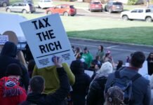 As Washington gets an income tax, the fight to overturn it begins Unions and other supporters of the income tax on millionaire earners rally at the Capitol on Feb. 10, 2026