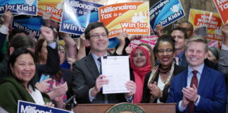 Supporters of Washington’s new income tax on millionaires celebrate after Gov. Bob Ferguson signs the bill into law on Monday March 30, 2026