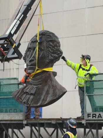A contractor removes a 500-pound George Washington bust from the General Administration Building before taking it to storage. The bust was part of a state seal that was affixed to the side of the building. 