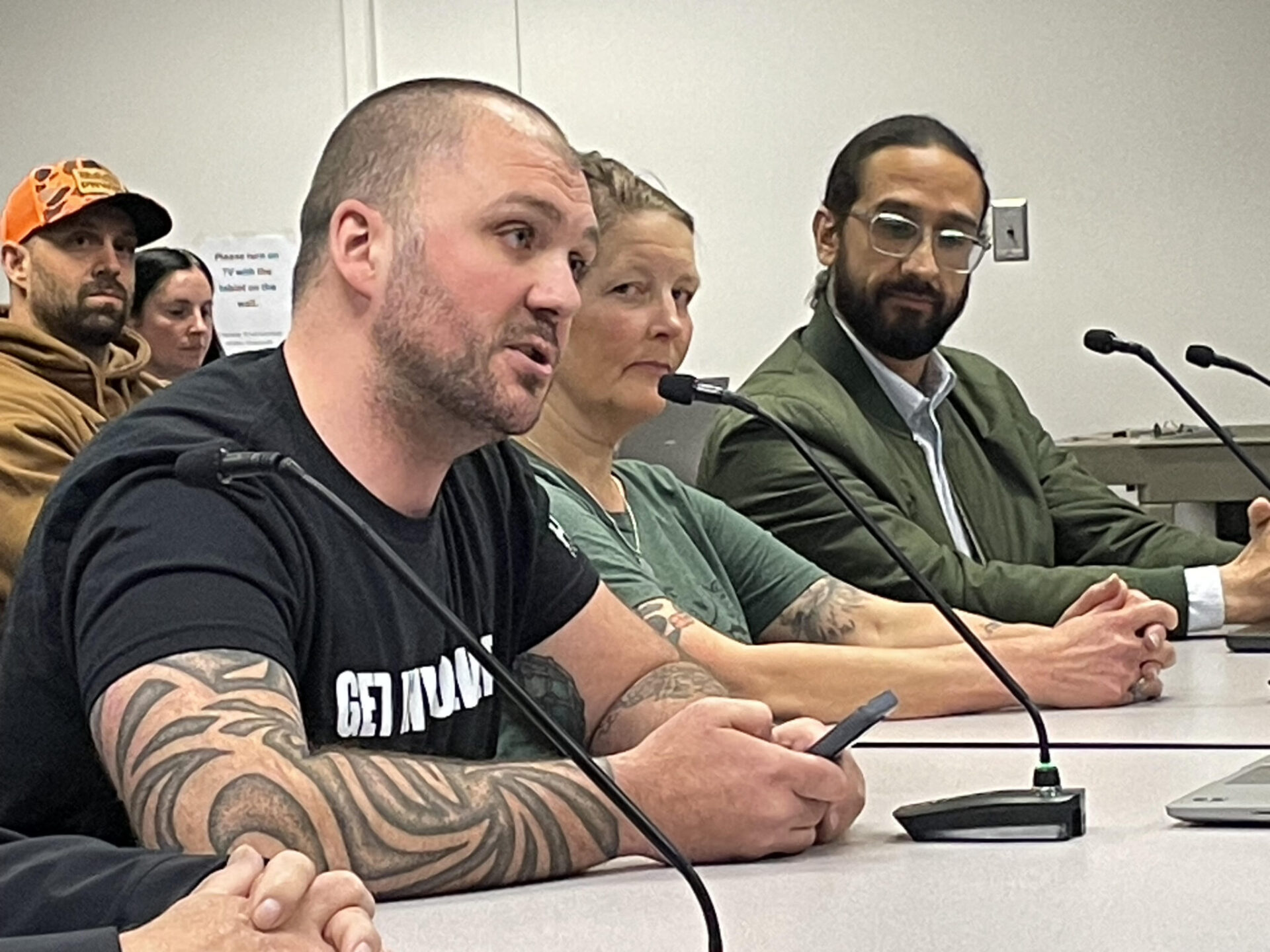 Cory Maxwell of Kitsap County (left) called on some members of the Washington Fish and Wildlife Commission to step down in public comments on April 17, 2026. Rachel Bjork and Francisco Santiago-Avila look on.