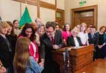 Gov. Bob Ferguson hands over one of the pens he used to sign House Bill 1296, the ‘students bill of rights’ to a child who attended the bill signing