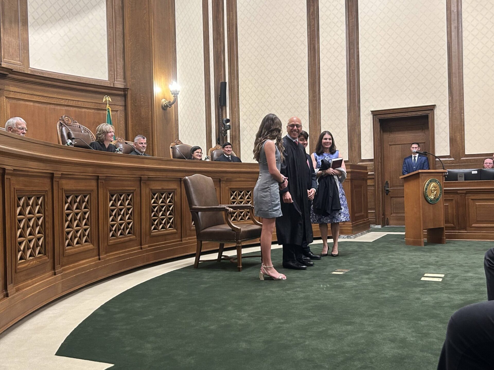 Washington state Supreme Court Justice Theo Angelis dons his robe alongside wife Kim and children Katherine and John as he is sworn in as a justice at the Temple of Justice on Monday, May 18, 2026, in Olympia