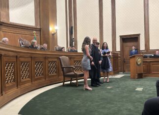 Washington state Supreme Court Justice Theo Angelis dons his robe alongside wife Kim and children Katherine and John as he is sworn in as a justice at the Temple of Justice on Monday, May 18, 2026, in Olympia