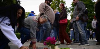 Community members place electric candles near a vase of flowers during a vigil at R.A. Long Park following a fatal chemical storage tank failure on May 26, 2026 in Longview, Washington.
