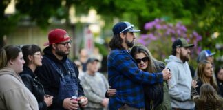 Community members comfort each other during a vigil at R.A. Long Park following a fatal chemical storage tank failure on May 26, 2026 in Longview, Washington.
