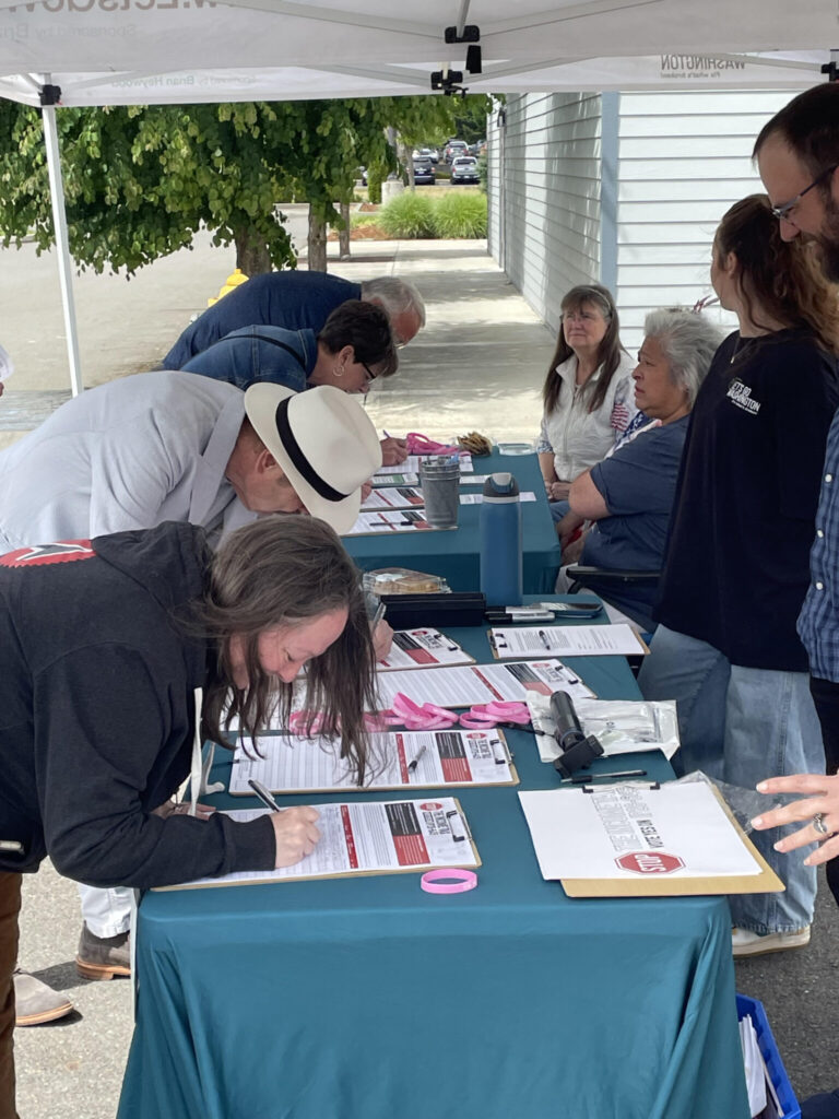 A steady stream of people signed petitions for a proposed ballot measure to repeal Washington’s new income tax on high earners. These signatures were gathered in Tumwater in early June by Let’s Go Washington, the initiative sponsors.