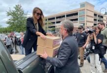 Ashley Butenschoen, a volunteer for Let’s Go Washington, hands boxes of ballot initiative petitions to the group’s founder, Brian Heywood, on Thursday, July 2, 2026, at the secretary of state’s office in Tumwater.