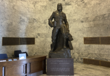 A bronze Marcus Whitman statue in the Washington state Capitol building weighs over 9,000 pounds with its stone base. (Jacquelyn Jimenez Romero/Washington State Standard)