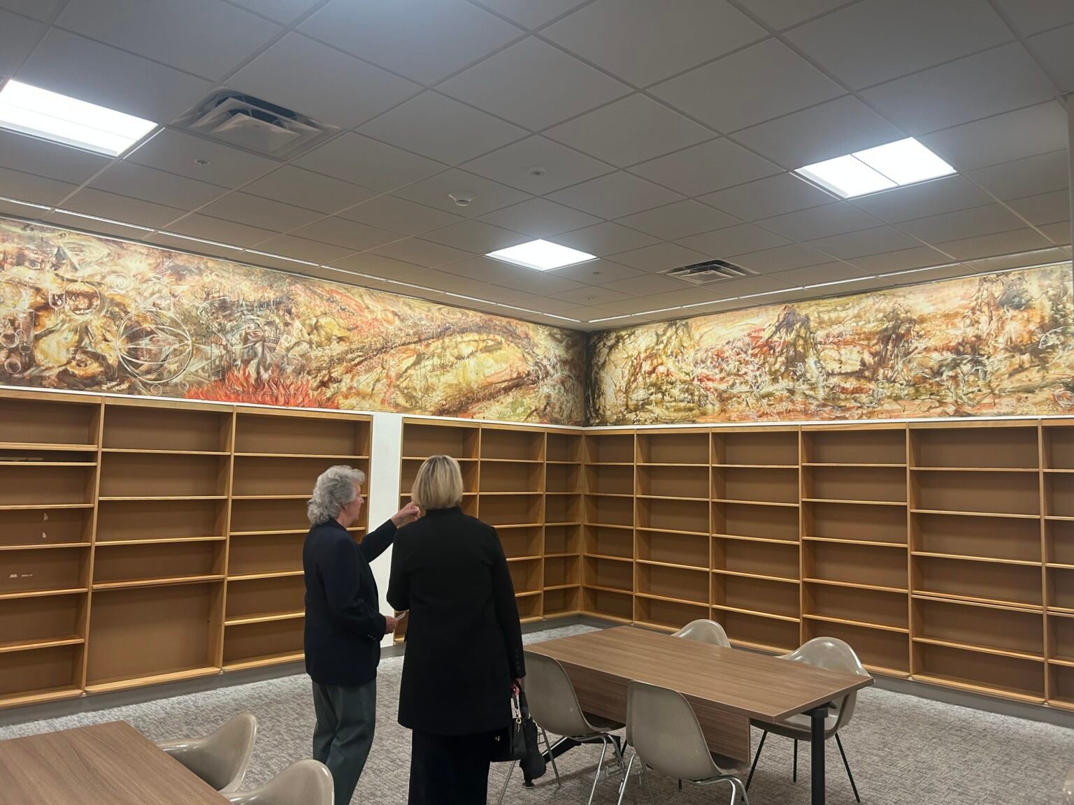 Two visitors take in the Kenneth Callahan mural in the Washington Room of the reopened Joel Pritchard Building. (Photo by Jake Goldstein-Street/Washington State Standard)