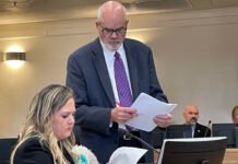 Washington state Rep. Tarra Simmons discusses documents with her attorney, Doug McKinley, before testifying at a hearing in June 2026 on allegations she violated state ethics laws. (Photo by Jerry Cornfield/Washington State Standard)