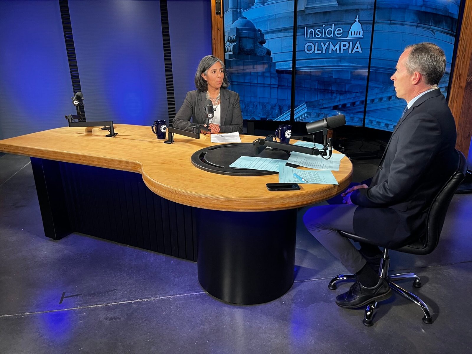 Department of Social and Health Services Secretary Angela Ramirez, left, discusses her department’s approach to tight state budgets and federal policy changes with “Inside Olympia” host Austin Jenkins, right. (Photo courtesy of TVW)