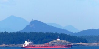 Increased tanker traffic through the shared border waters of Washington and British Columbia could rise further if Alberta succeeds in building a new crude export pipeline to the West Coast. Here, an oil/chemical tanker steers through Boundary Pass on the way to the Port of Vancouver in late June. (Photo credit by Tom Banse)