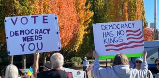 No Kings demonstrators carried signs on Oct. 17, 2026, bearing messages about the importance of both voting and voting early to prevent doubt later when results are tallied. (Photo by Jerry Cornfield/Washington State Standard)